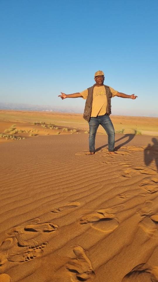 A person standing in the sand

Description automatically generated